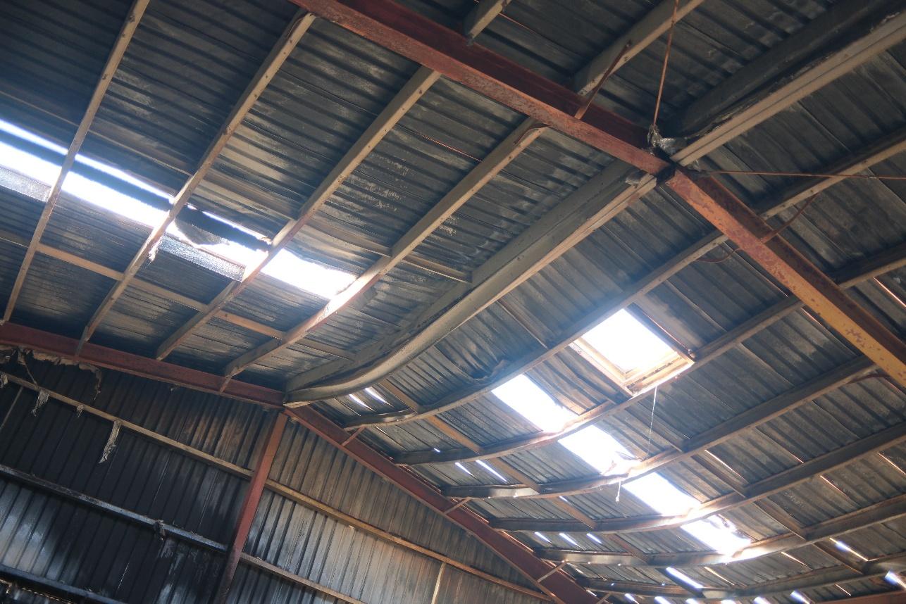 Heat-deformed steel roof purlins inside a fire-damaged building