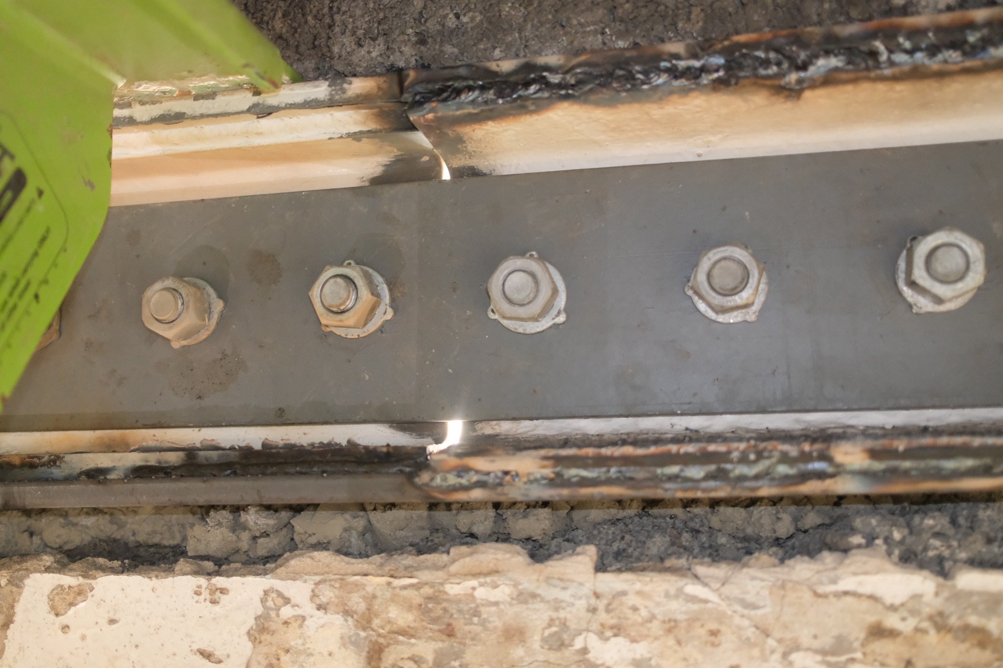 Bolted steel beam web splice installed within an existing building